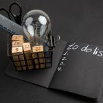 Master the 80/20 Rule for Ultimate Productivity Success bottom-view-office-stuffs-pen-case-list-written-black-notepad-black-table