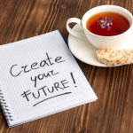 top-view-cup-tea-with-copybook-brown-desk